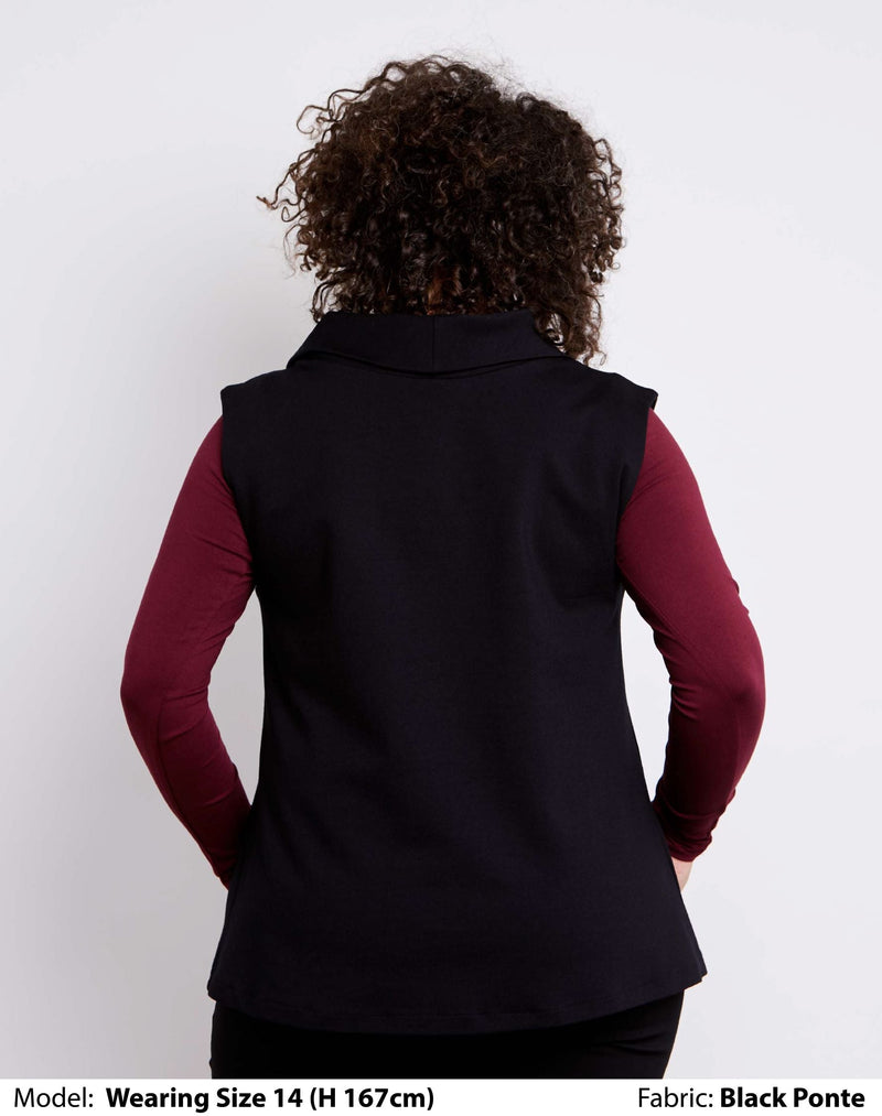 Back view of size 14 model dressed for work in a womens plus size vest with collar in black Low pill ponte.