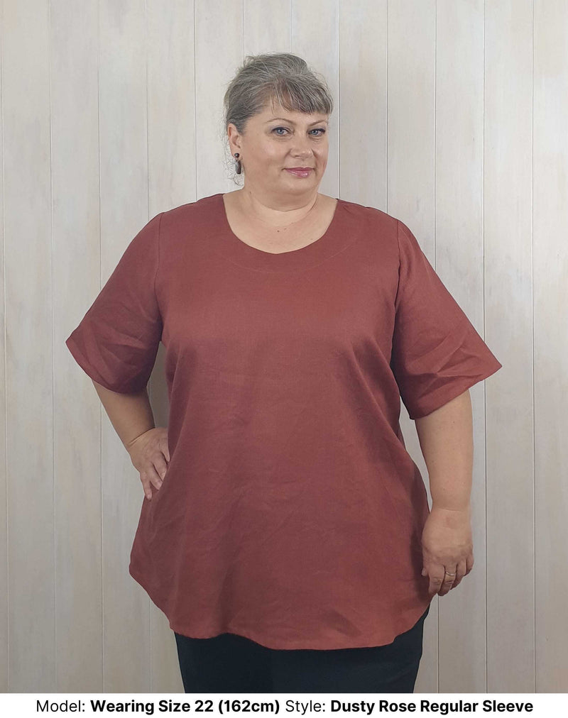 Size 22 model wears plus size curvy long pink clay dusty rose linen blouse with elbow length short sleeves sleeves to fit larger upper arms and biceps available in sizes 14 to 26
