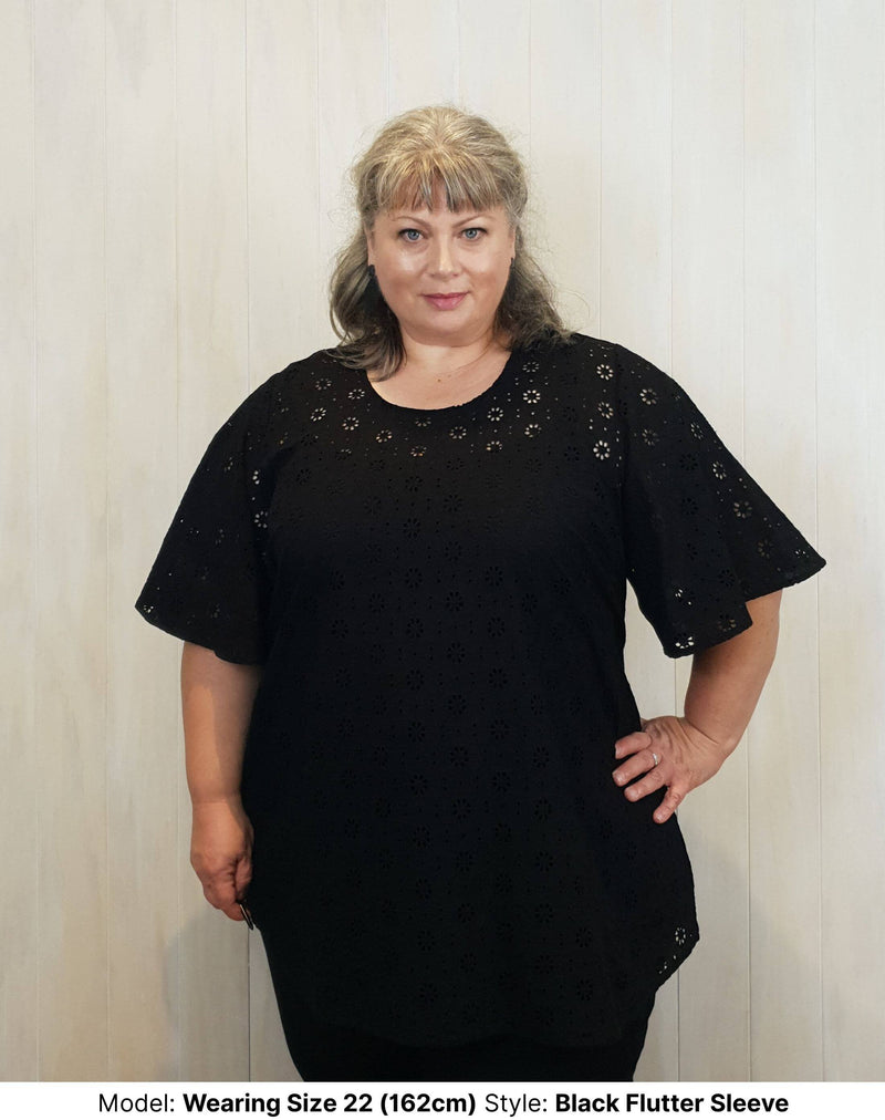 Size 22 model wearing black cotton broderie anglaise extra long blouse with wide short sleeves available in sizes 14 to 26 ethically made in Australia