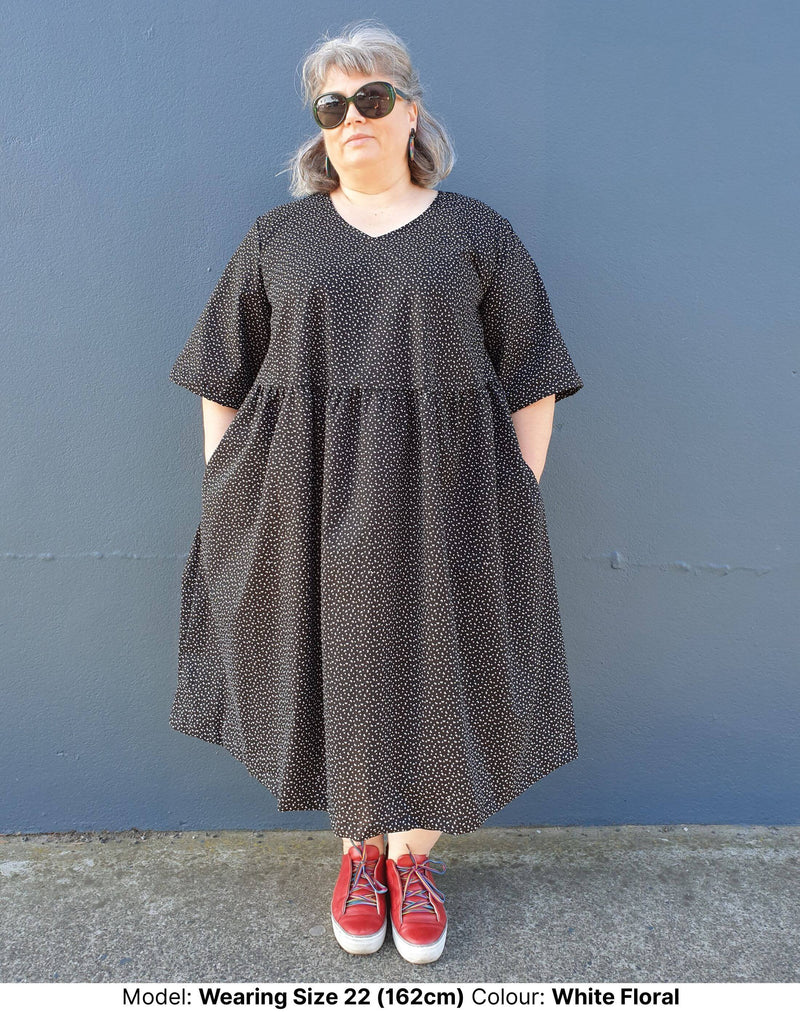 Model wearing size 22 plus size midi dress in black cotton with small floral motif