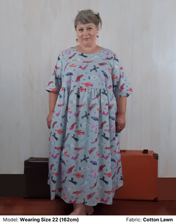 Front view of model wearing plus size Chasing Springtime Millican Frock in pure cotton size 22. The print on the dress is Gabriele Larios's print which is multi-coloured birds on a muted duck-egg blue background.