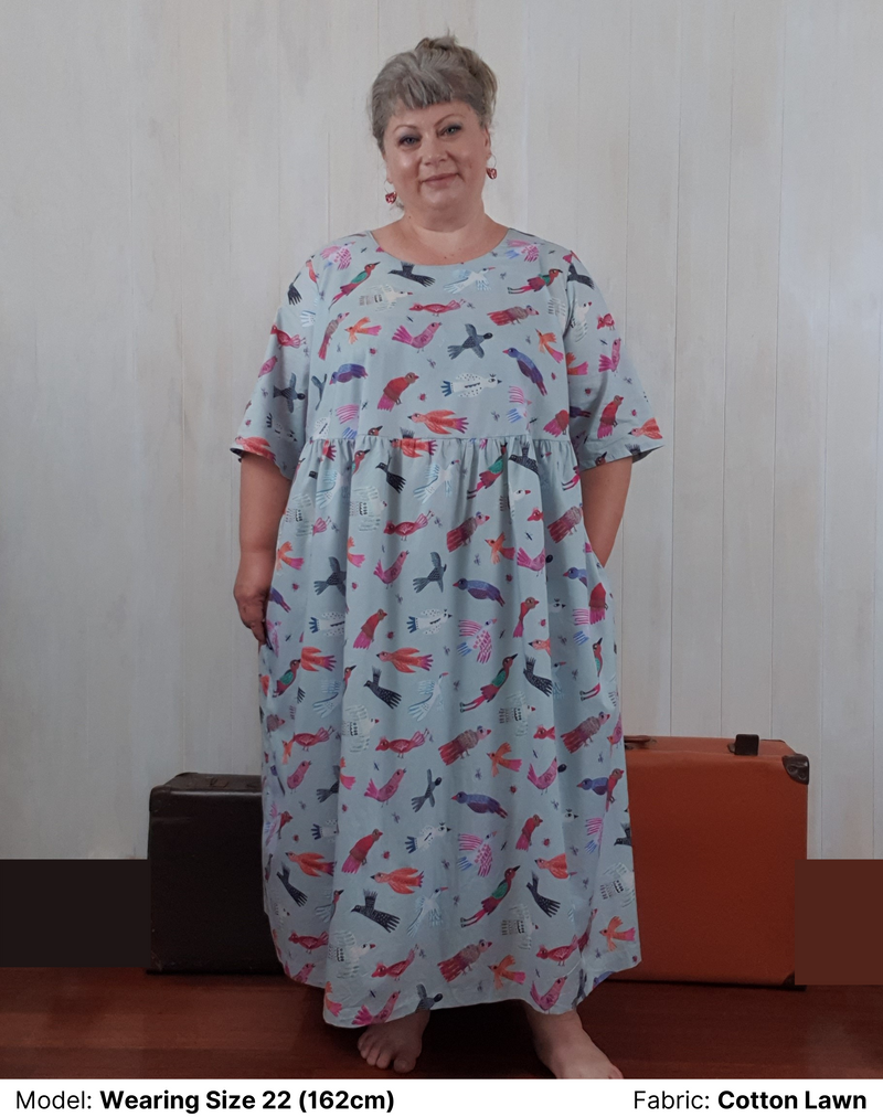 Front view of model wearing Chasing Springtime Millican Frock in pure cotton size 22. The print on the plus size dress is Gabriele Larios's print which is multi-coloured birds on a muted duck-egg blue background.