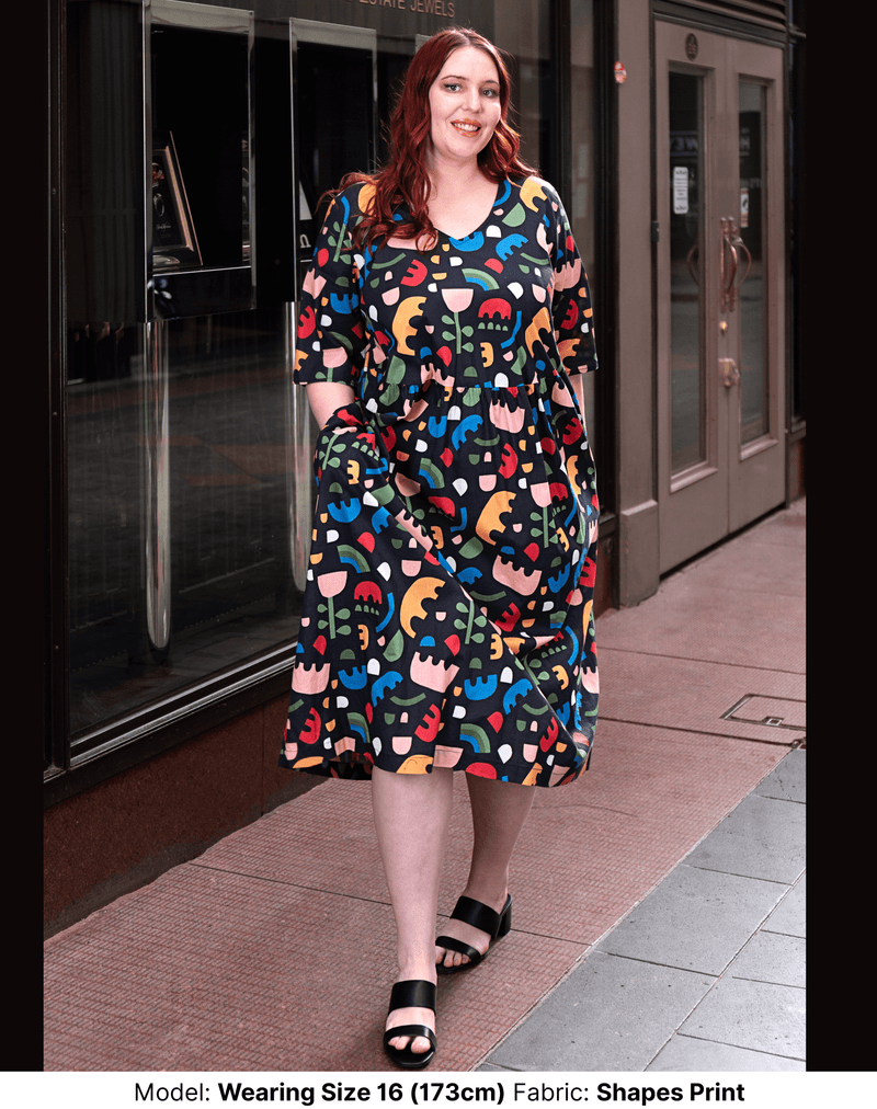 model wearing size 16 plus size shapes print dress with extra wide sleeves, v neck and pockets