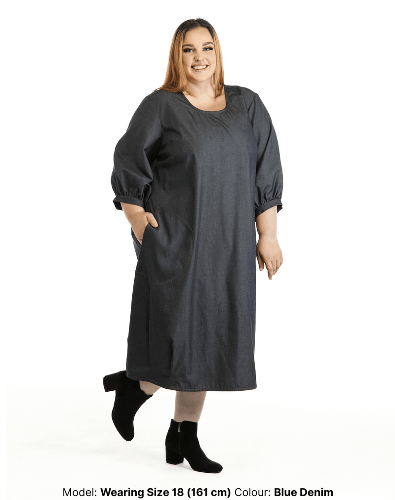 Side view of model with hand in her pocket of Zemiro plus size denim dress by Chasing Springtime