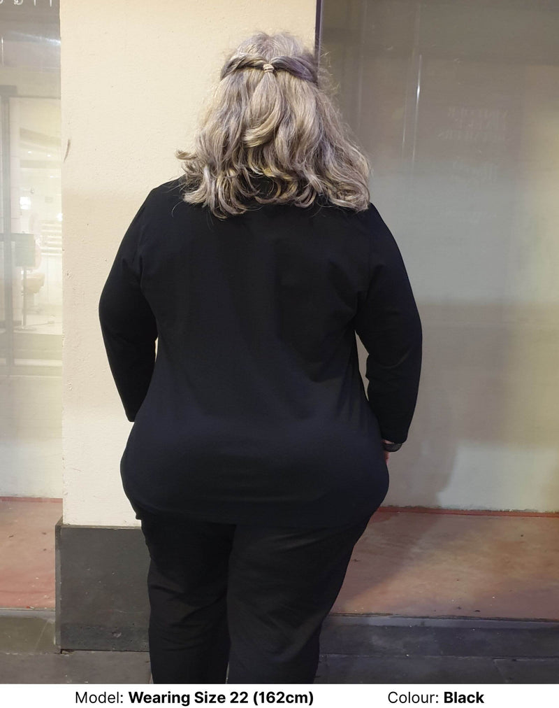 Plus size woman wearing black long sleeve tee facing the back